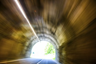 View from car during fast driving by car driver speeding car racer through long tunnel with