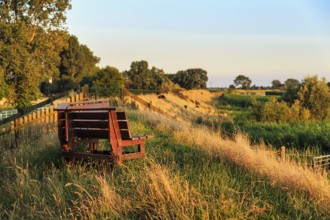 Wooden bench on dyke, evening light, river Stör, Kremper Marsch, Hodorf, Itzehoe,