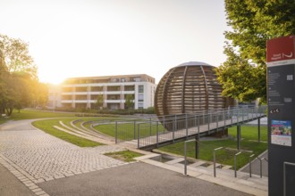 Modern architecture with a spherical building in the warm evening light, small town of Perle