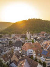 Sunny view of an old town with church and hills in the background at sunset, small town pearl