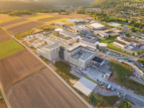 Industrial complex in a rural setting at sunset with neighbouring fields, new hospital building,
