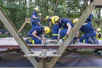 Construction of a temporary bridge over a slipped road crossing a stream, by the bridge