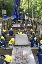 Construction of a temporary bridge over a slipped road crossing a stream, by the bridge