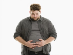 Overweight young man looks worried and holds his hands on his stomach, AI generated, AI generated