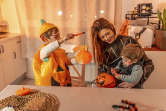 Family wearing halloween costumes and makeup are playing with pumpkin baskets in a kitchen