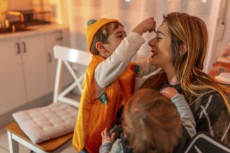 Happy family preparing for a halloween party, applying colorful makeup together at home, creating