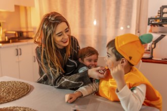 Smiling and playing together in the kitchen, a happy family enjoys halloween festivities while