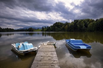 Rowing boat and pedal boats lying on a bathing jetty, jetty, wooden jetty, jetty, leads into a