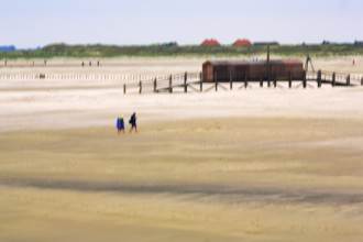Strollers on the North Sea beach, pile dwelling, stilt house, wiping effect, long exposure, Sankt
