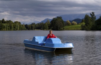 Woman, blonde, red jacket, riding pedal boat, bathing lake, lake, Schwaltenweiher near Seeg, Allgäu