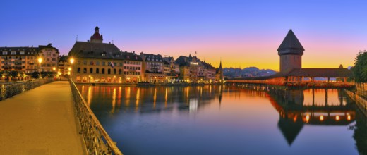 Chapel bridge with water tower reflected in the river Reuss, panorama of Lucerne's old town at