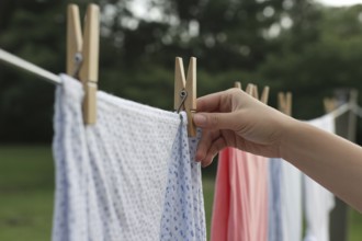 Laundry hanging with wooden cloth pegs. Everyday household routine and simplicity. Generative ai,