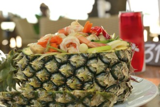 Pineapple fried rice with shrimp and vegetables served in a pineapple, a popular thai dish,