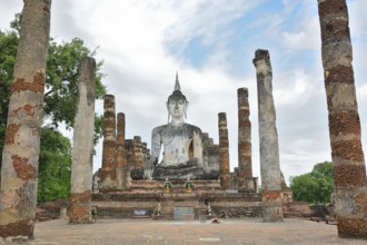 Serene buddha statue sits majestically amidst ancient ruins, showcasing the rich spiritual and