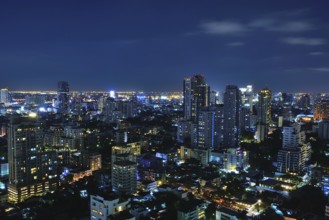 Bangkok's vibrant skyline at night, showcasing illuminated skyscrapers and bustling urban life in