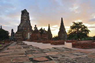 Serene buddha statues sit amidst crumbling temple ruins, bathed in the golden light of a beautiful