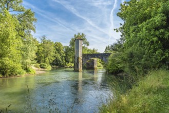 Scenic view of the historic stone bridge over the gave d'oloron river, surrounded by lush greenery,