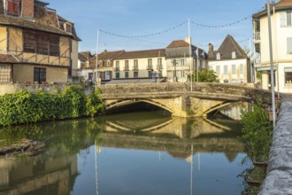 Scenic view of the old stone bridge reflecting in the calm river during a sunny morning in the
