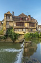 Serene waters reflecting the charm of historic houses in the enchanting village of salies de bearn,