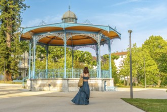 Tourist walking away from a bandstand in salies de bearn, a charming village in the pyrenees