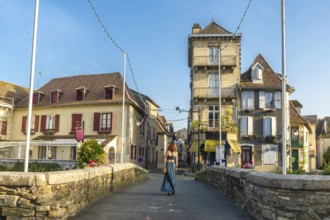 Young woman walking across a bridge in the historic village of salies de bearn, france, enjoying