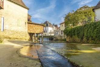 Scenic view of a small waterfall flowing through the charming village of salies de bearn in the