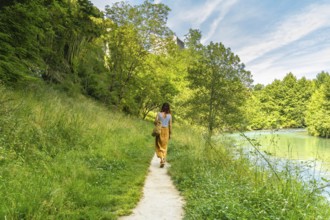 Tourist enjoying a peaceful walk along the gave d'oloron river in sauveterre de bearn, a charming