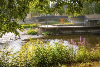 Urban river landscape with a bridge and industrial features, embedded in greenery, Nagold, district