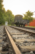 Railway tracks in the foreground leading to a historic train carriage, Nagold, district of Calw,