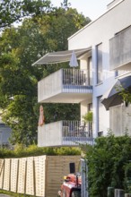 View of balconies on a modern residential building with surrounding trees, Nagold, district of