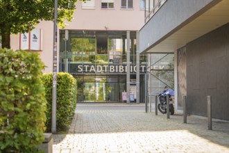 Modern entrance to a municipal library with glass façade and a motorbike in front, Nagold, district
