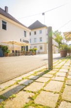 Cosy street scene with a café and seating, surrounded by sun-drenched buildings, Nagold, district