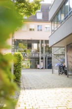 City library entrance in an urban environment with glass façade and green landscape, Nagold, Calw