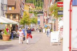 Lively street in an old town with passers-by and hustle and bustle on a sunny day, small town pearl