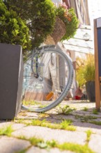 A bicycle wrapped in flowers next to shutters and in the sunshine, small town of Perle Calw,