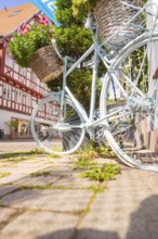 Close-up of a bicycle in front of half-timbered houses in sunlight, small town of Perle Calw,