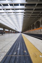 A modern underground station with structural lighting and empty platforms, Munich, Germany