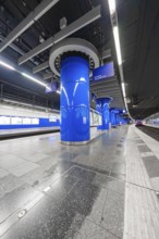 Modern underground station with blue columns and urban flair, Munich, Germany