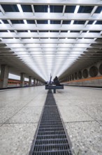 Symmetrical station concourse with modern benches and bright lighting, Munich, Germany