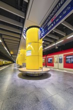 Underground station with striking yellow columns and urban ambience, Munich, Germany