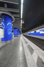 Modern underground station with blue design, empty platforms and smooth surfaces, Munich, Germany