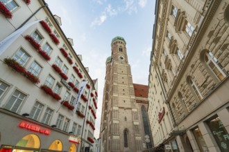 Historically significant church tower surrounded by old buildings under a clear sky, Munich,