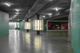 A modern, urban tunnel with coloured neon lights creates an industrial-looking atmosphere, Munich,