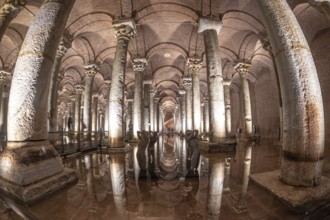 Ancient basilica cistern with many columns reflecting on water surface with sculptures and