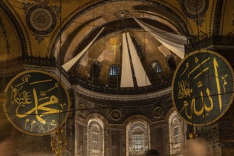 Interior view of hagia sophia showcasing islamic calligraphy, the central dome, and architectural