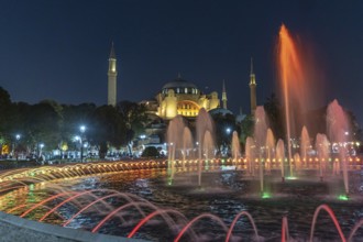Colorful illuminated fountain jets dancing in front of the hagia sophia in istanbul, turkey,