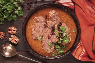 Fesenjan, an Iranian dish, stewed chicken, in walnut-pomegranate sauce, in an earthen pan,