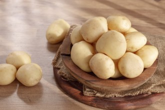 Boiled new potatoes, in a wooden bowl, on a rustic table, natural light, no people