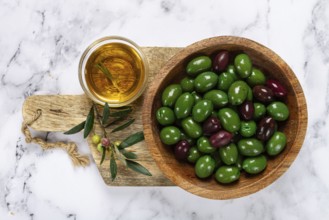 Chalkidiki olives, classic Greek green olives, in a bowl on a cutting board, top view, without
