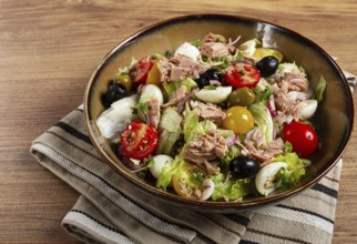 Salad with canned tuna, vegetable salad with quail eggs, lettuce, red onion, cherry tomatoes,